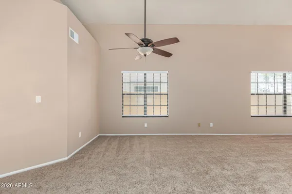 an empty room with windows and fan