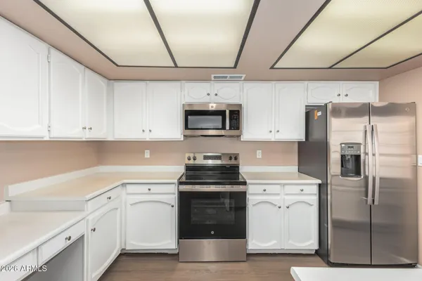 a kitchen with white cabinets and stainless steel appliances