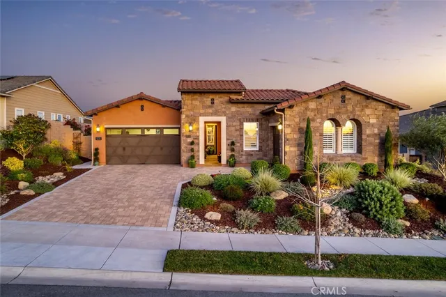 a front view of a house with a yard and potted plants