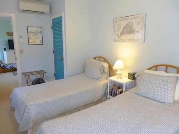 a bedroom with two beds and painting on the wall