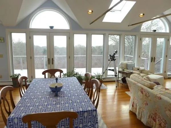 a living room with furniture a large window and wooden floor