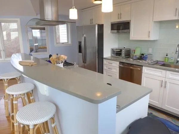 a kitchen with stainless steel appliances a table and chairs in it