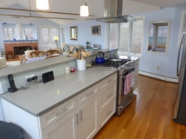 a kitchen with stainless steel appliances a sink stove and wooden floor