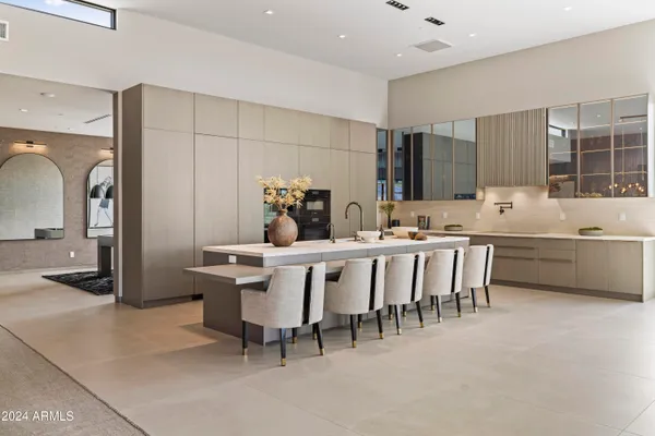 a large white kitchen with a large window and cabinets