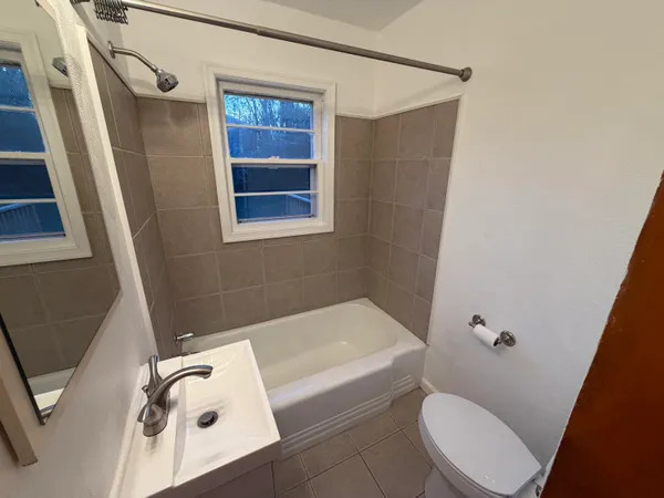 an empty room with windows fireplace and wooden floor