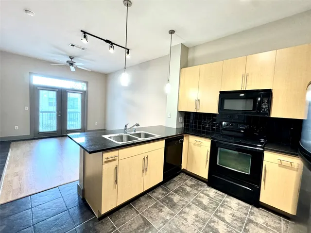 a kitchen with stainless steel appliances granite countertop a stove a sink and a microwave