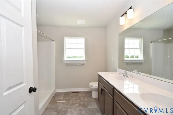 a bathroom with a granite countertop sink a toilet and shower