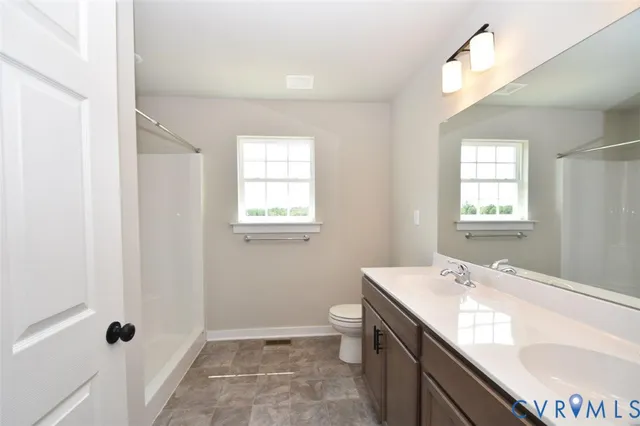 a bathroom with a granite countertop sink a toilet and shower