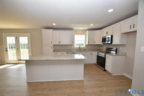 a view of a kitchen with refrigerator and wooden floor