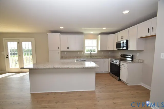 a view of a kitchen with refrigerator and wooden floor