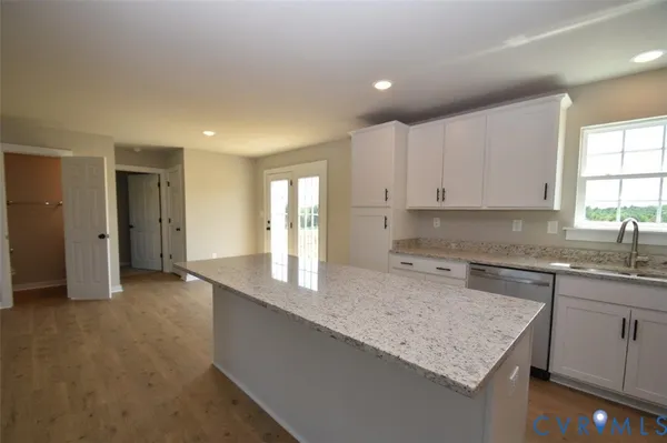 a kitchen with granite countertop cabinets stainless steel appliances a sink and a window