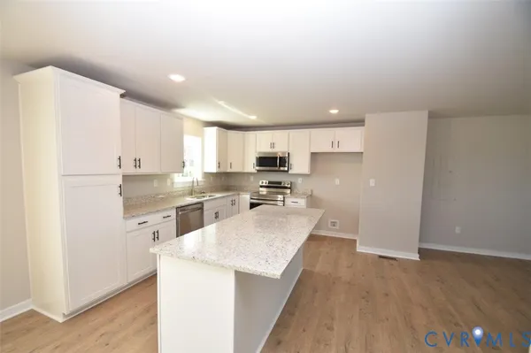 a kitchen with granite countertop a sink stove and cabinets