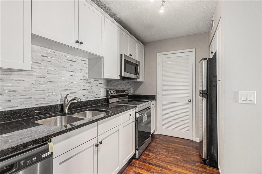 2657 Lenox Road Northeast, Unit 69 Atlanta, GA 30324 - Photo 11 of 31 a kitchen with granite countertop a sink stainless steel appliances and cabinets