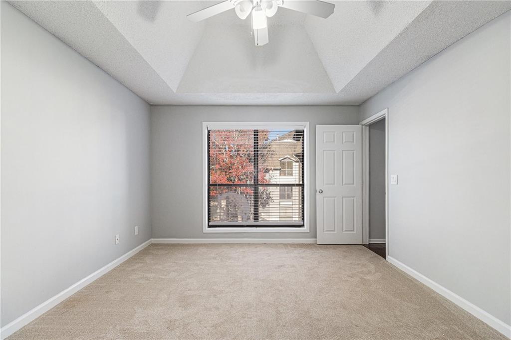2657 Lenox Road Northeast, Unit 69 Atlanta, GA 30324 - Photo 15 of 31 an empty room with windows and chandelier fan