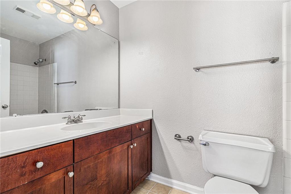 2657 Lenox Road Northeast, Unit 69 Atlanta, GA 30324 - Photo 16 of 31 a bathroom with a sink vanity mirror and toilet