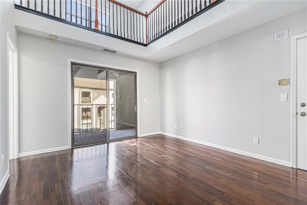 2657 Lenox Road Northeast, Unit 69 Atlanta, GA 30324 - Photo 7 of 31 an empty room with wooden floor and windows