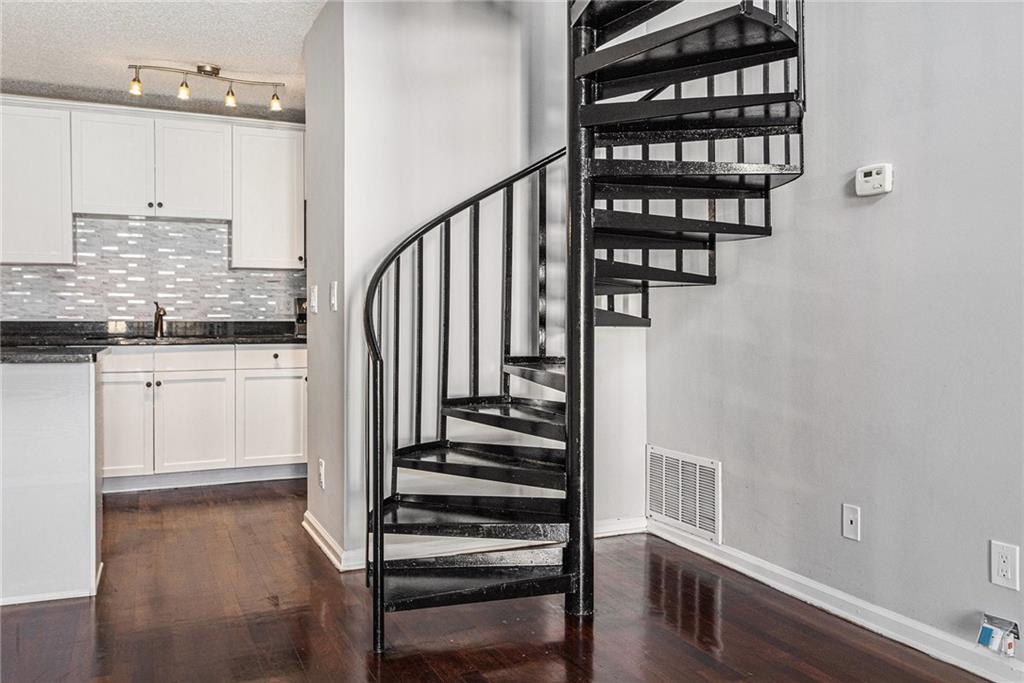 2657 Lenox Road Northeast, Unit 69 Atlanta, GA 30324 - Photo 8 of 31 a kitchen with granite countertop a stove a sink and dishwasher with wooden floor