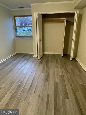 an empty room with wooden floor and entrance