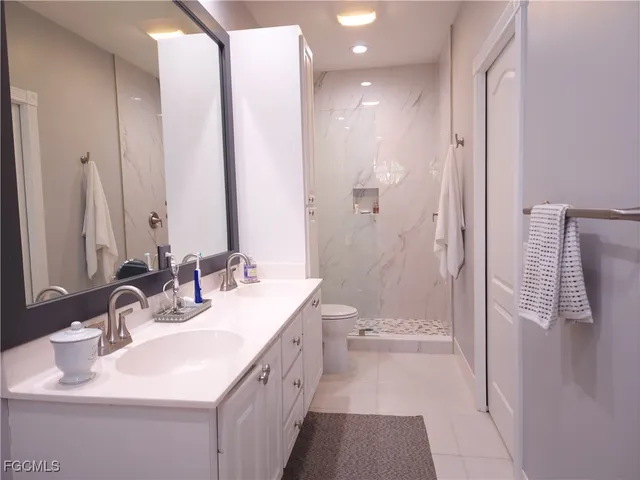 a bathroom with a double vanity sink mirror and shower