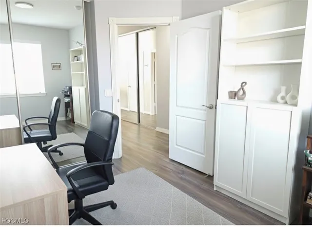 a view of a workspace with furniture and wooden floor