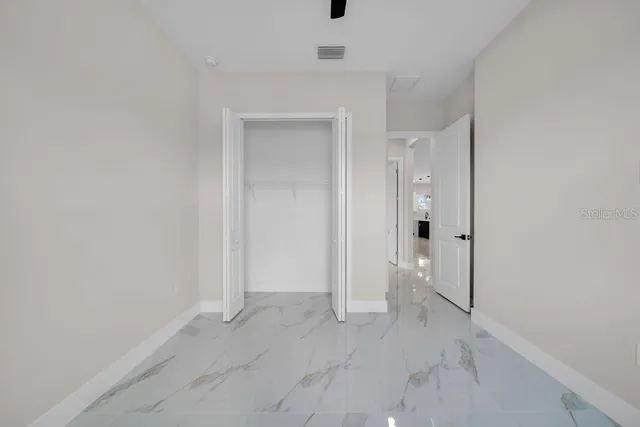 an empty room with a window and a fan