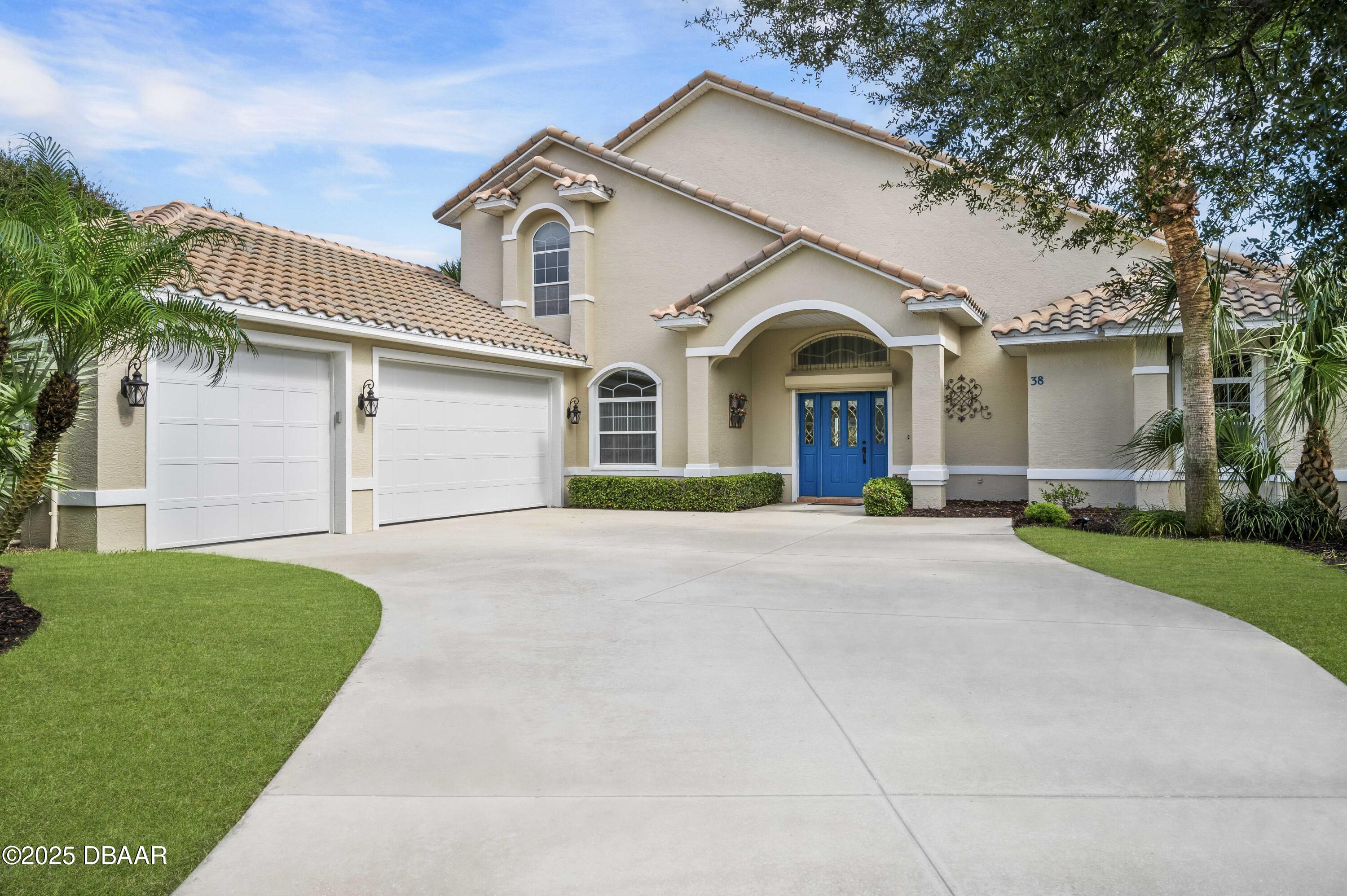 a view of a house with a yard and large tree
