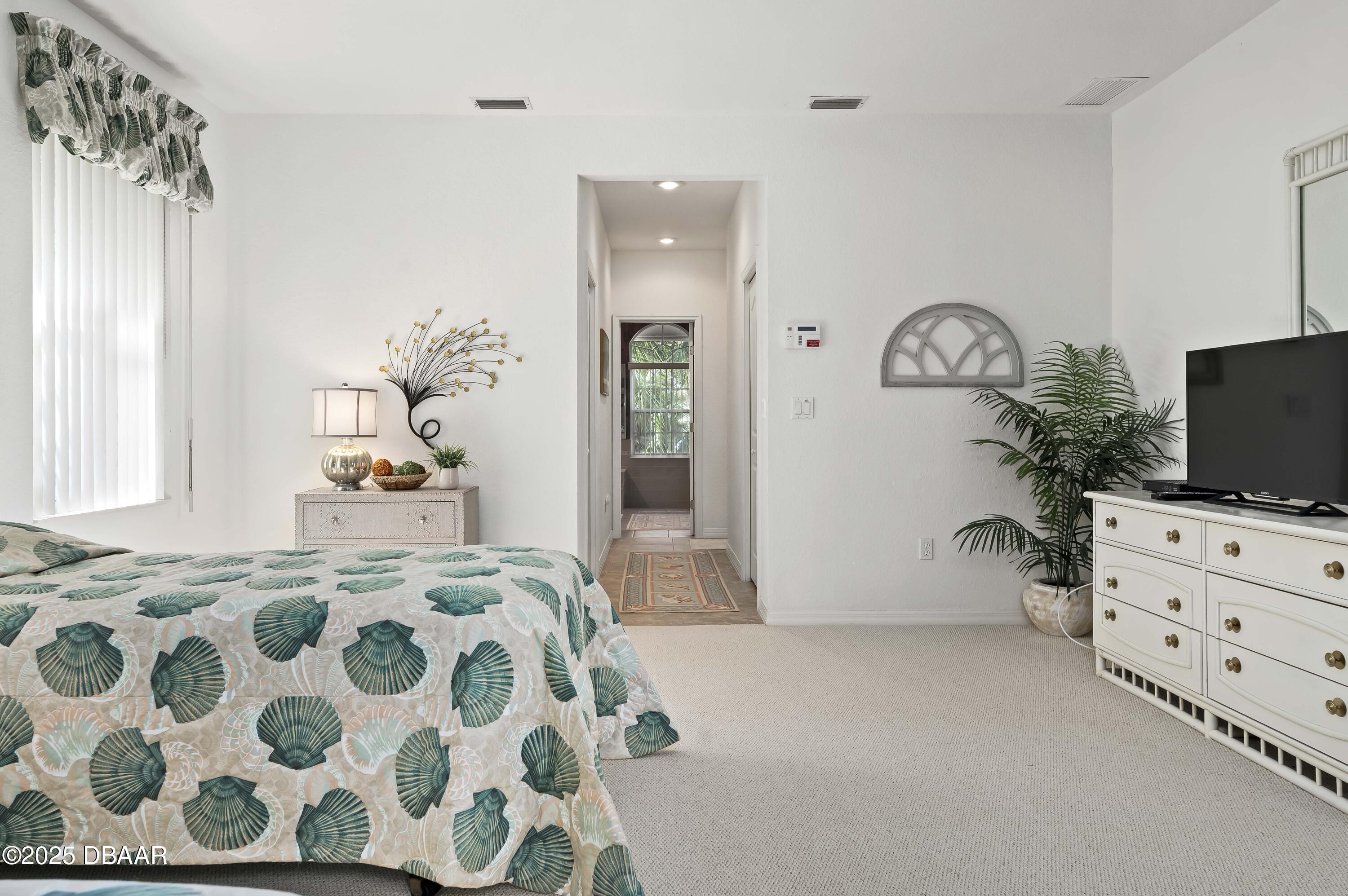 38 South Turn Circle Ponce Inlet, FL 32127 - Photo 17 of 49 a bedroom with a bed and a flat screen tv