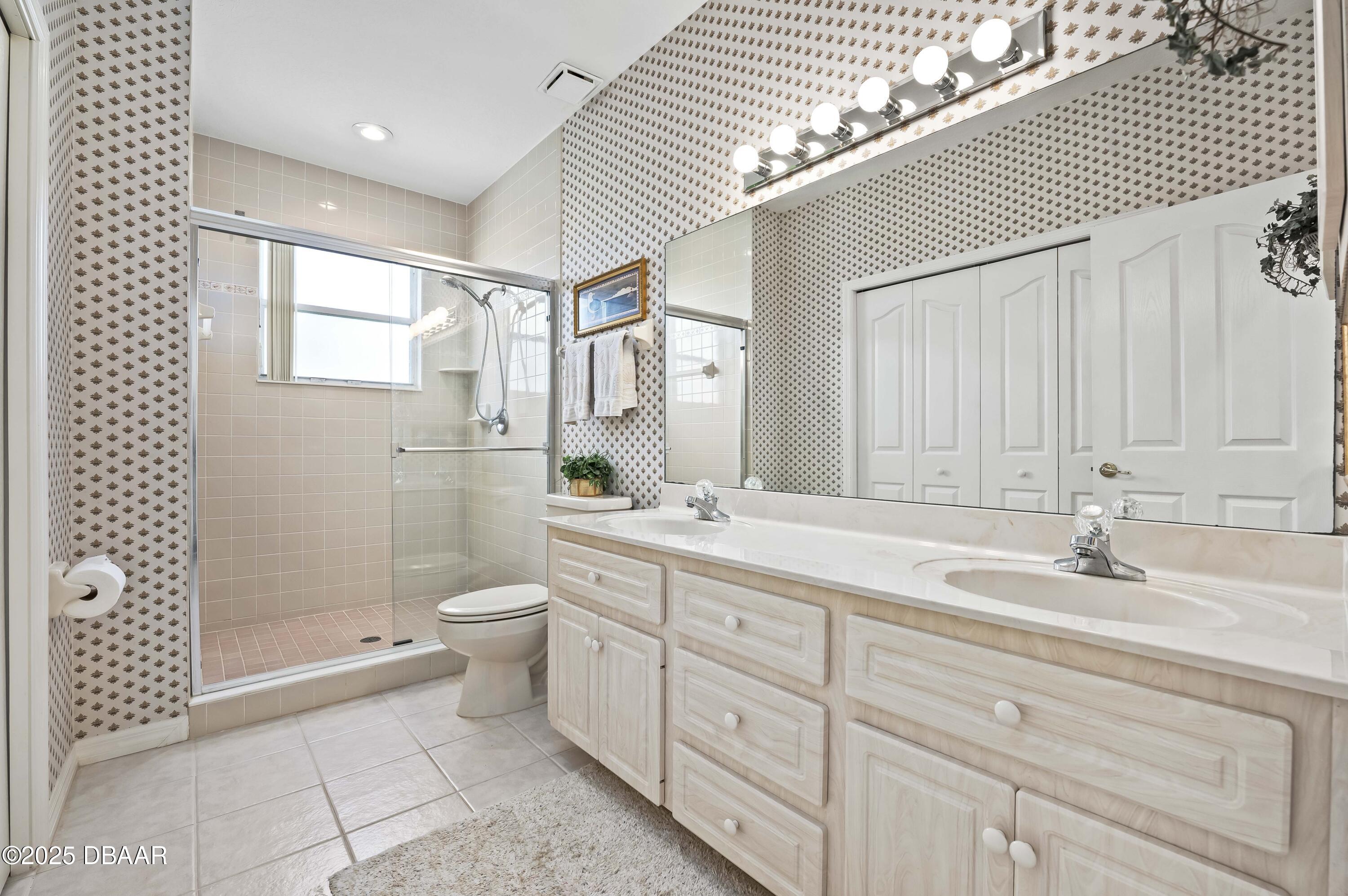 38 South Turn Circle Ponce Inlet, FL 32127 - Photo 28 of 49 a spacious bathroom with a double vanity sink toilet and shower