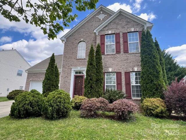 a front view of house with a garden
