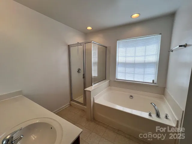 a bathroom with a tub sink and mirror