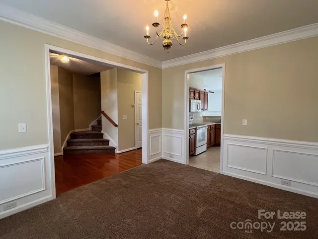a view of a hallway with wooden floor and a living room
