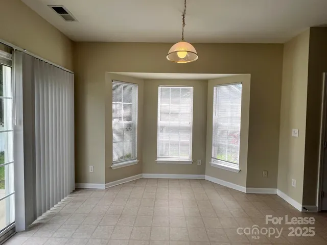 a view of an empty room with a fireplace and a window
