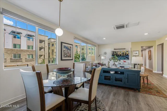 a dining room with furniture a chandelier and wooden floor
