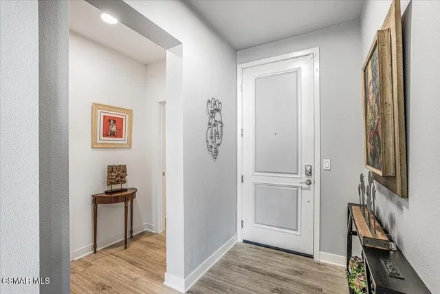 a view of a hallway with workspace and wooden floor