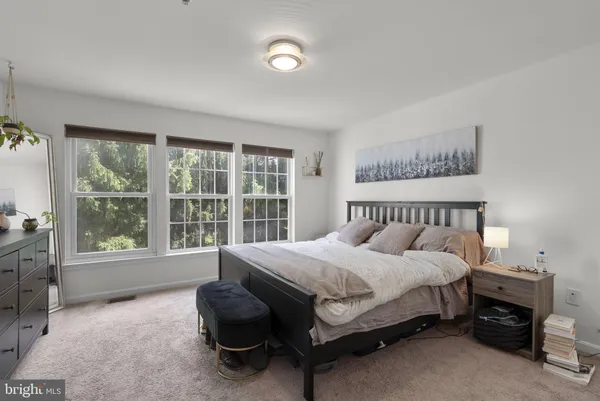 a bedroom with a bed and a large window