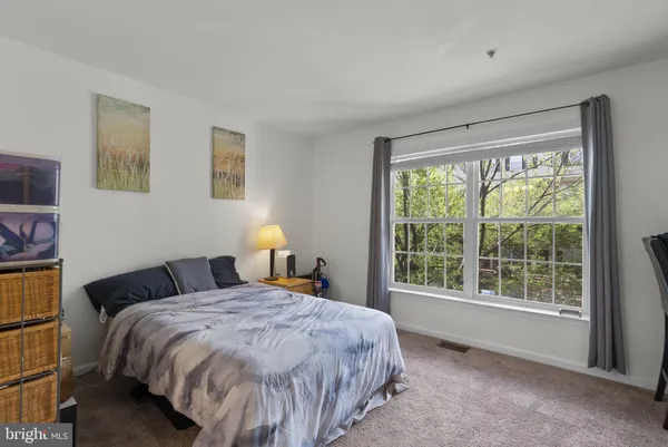 a bed sitting in a bedroom next to a window