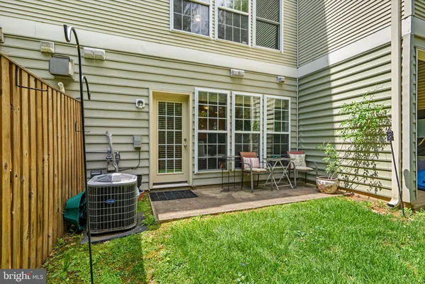 a front view of a house with a garden and chairs