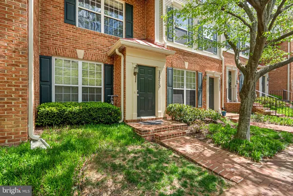 front view of a brick house with a yard