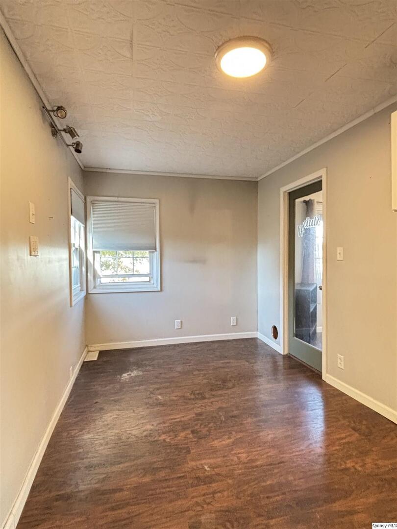 41 Main Street Carthage, IL 62321 - Photo 15 of 27 an empty room with wooden floor and windows