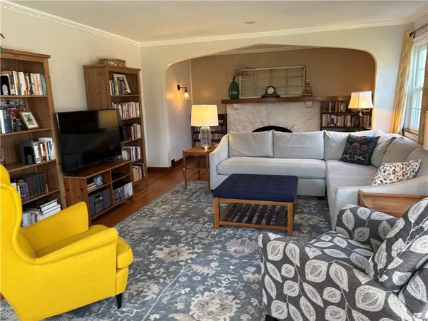 a living room with bookshelf and a fireplace