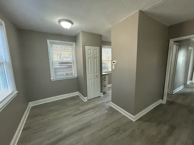 an empty room with windows and closet