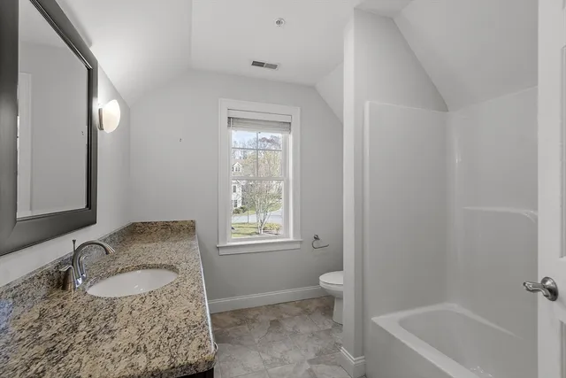 a bathroom with a granite countertop sink and a bathtub