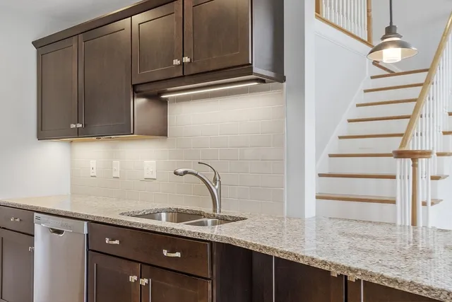 a kitchen with granite countertop a sink and cabinets