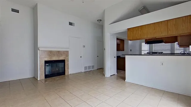 a view of an empty room with a fireplace and a window