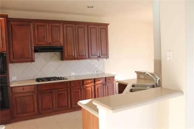 a kitchen with stainless steel appliances wooden cabinets and a sink