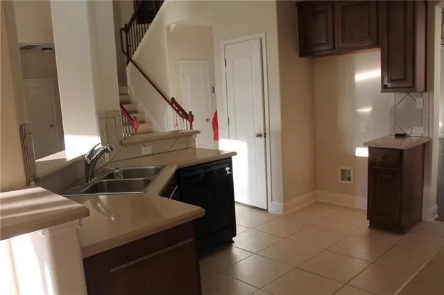 a kitchen with a sink a refrigerator and cabinets
