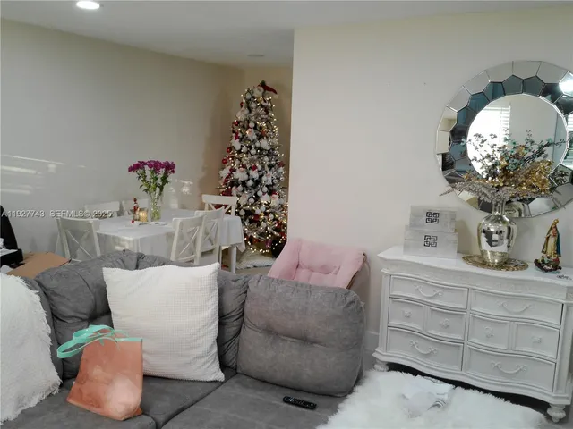 a living room with furniture a chandelier and a mirror