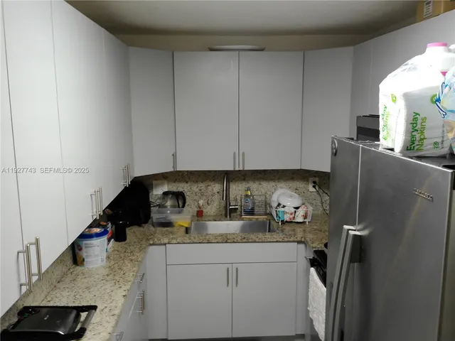 a kitchen with stainless steel appliances granite countertop a refrigerator and a stove