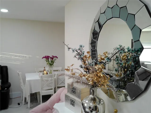 a vase of flowers sitting on a table with a mirror