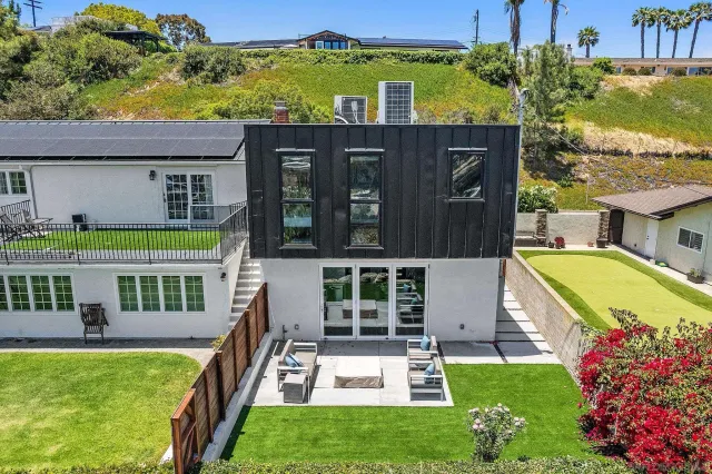 a view of a house with a big yard and potted plants